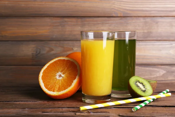 Oranje en kiwi-sap en vers fruit op houten tafel op houten muur achtergrond — Stockfoto
