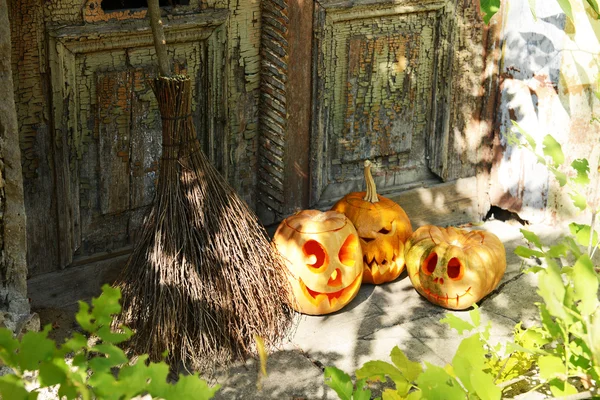 Dýně a koště pro svátek Halloween na pozadí staré dřevěné dveře — Stock fotografie