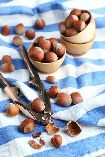 Hasselnötter i trä skålar, på servett bakgrund — Stockfoto