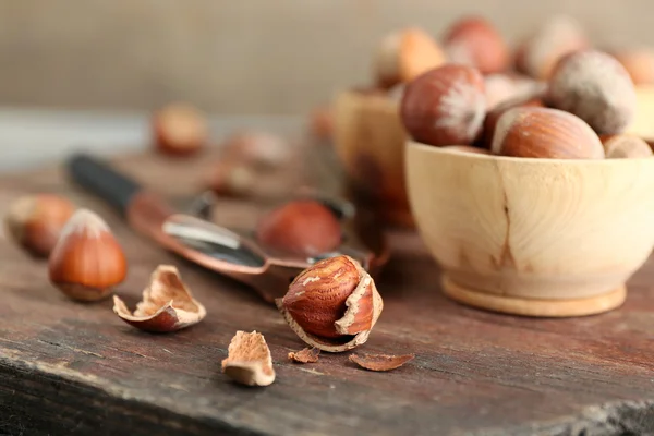 Hazelnuts in wooden bowls, on napkin on wooden background — Stock Photo, Image