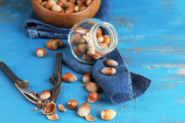 Hazelnuts in glass jar on wooden background — Stock Photo, Image