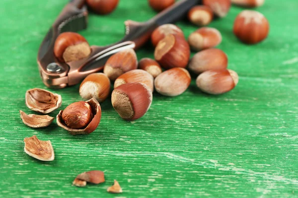 Hazelnuts and nutcracker on wooden background — Stock Photo, Image