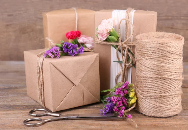 Belos presentes com flores e corda decorativa — Fotografia de Stock