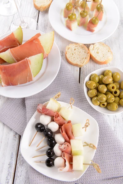 Läckra melon med prosciutto på tallriken på bordet närbild — Stockfoto