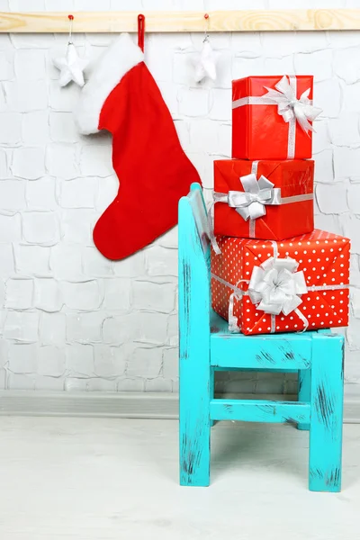 Christmas presents on blue chair on brick wall background — Stock Photo, Image