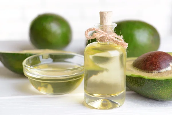 Avocado oil on table on light background — Stock Photo, Image