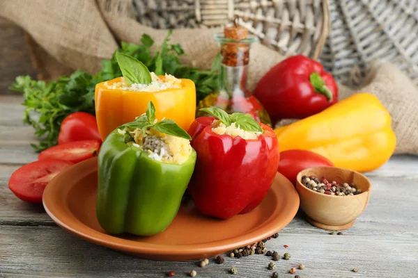 Composition with stuffed peppers on plate and fresh herbs, spices and vegetables, on wooden background — Stock Photo, Image