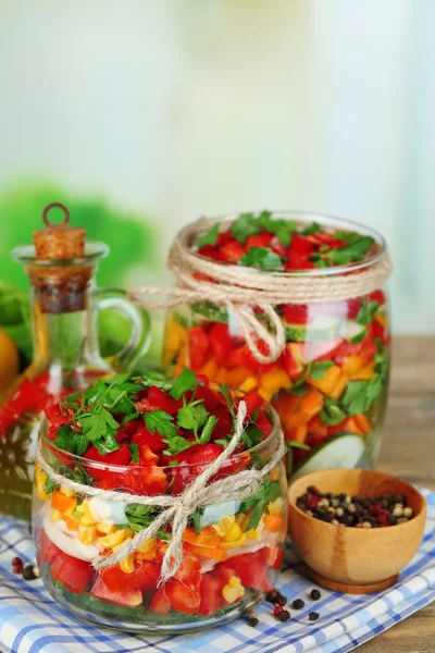 Grönsakssallad i glasburkar på träbord, på ljus bakgrund — Stockfoto