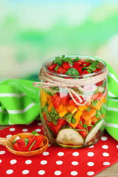 Insalata di verdure in vaso di vetro su tavolo di legno, su sfondo luminoso — Foto Stock