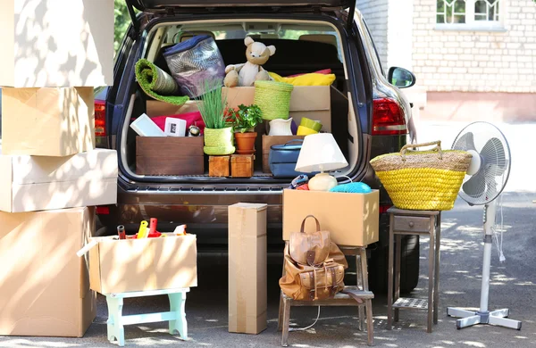 Flytta lådor och väskor i bakluckan på bilen, utomhus — Stockfoto