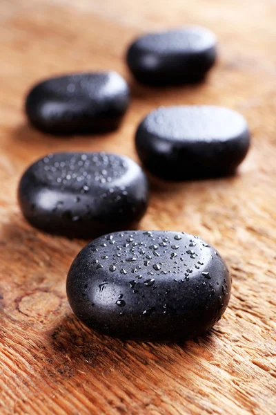 Piedras de spa con gotas sobre fondo de madera —  Fotos de Stock