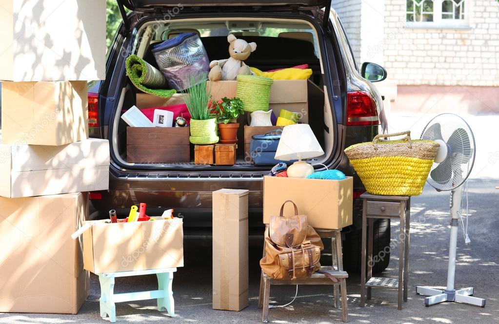 Moving boxes and suitcases in trunk of car, outdoors