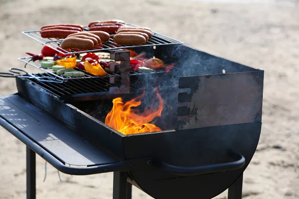 Sausages and vegetables on barbecue grill, outdoors — Stock Photo, Image