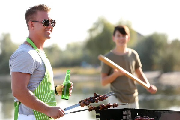 Mladí přátelé s barbecue party venku — Stock fotografie