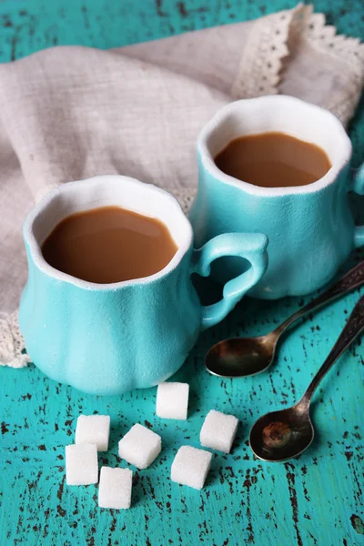 Tazas de café con azúcar y servilleta sobre mesa de madera — Foto de Stock