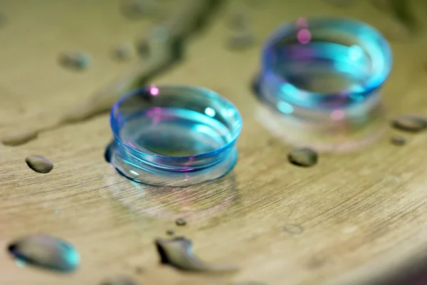Kontaktlinsen mit Wassertropfen auf hellem Hintergrund — Stockfoto