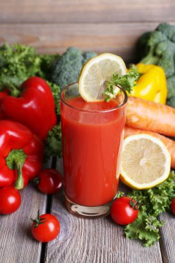 Cam ve ahşap duvar arka plan üzerinde ahşap masa üzerinde taze sebze domates suyu