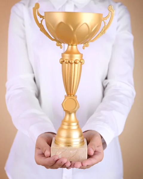 Woman holding trophy cup on color background — Stock Photo, Image