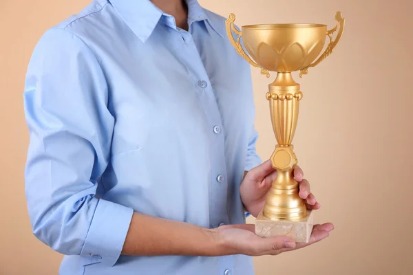 Femme tenant coupe trophée sur fond de couleur — Photo