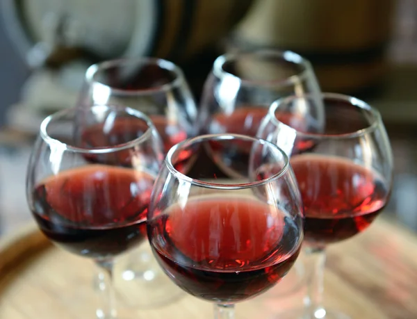 Glazen wijn in de kelder met de oude vaten — Stockfoto