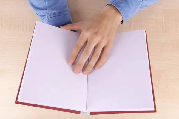 Män läser tömma öppen bok på träbord bakgrund — Stockfoto