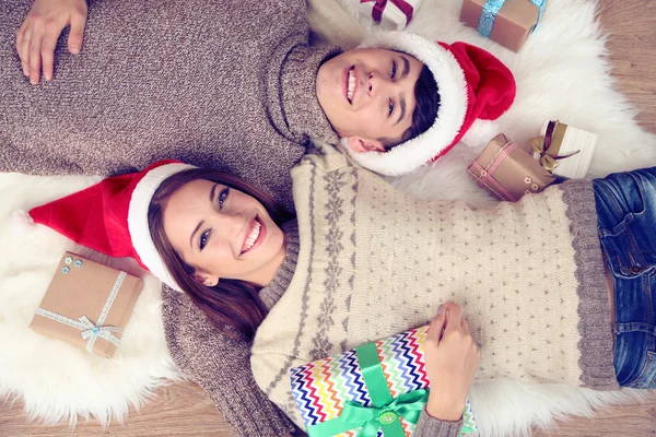 Счастливая пара с рождественскими подарками расслабляющий дома — стоковое фото