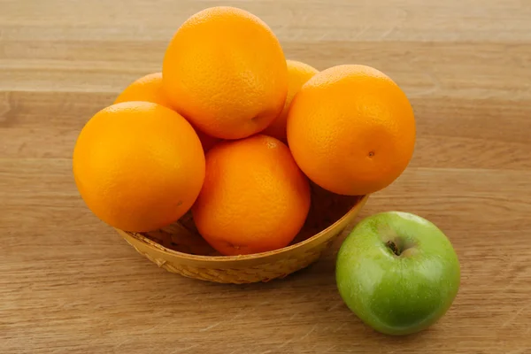 Juicy oranges and apple on wooden table, close-up — Stock Photo, Image