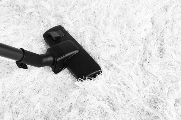 Aspirador de pó no tapete branco — Fotografia de Stock