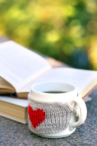 Cup with hot drink and book, outdoors — Stock Photo, Image