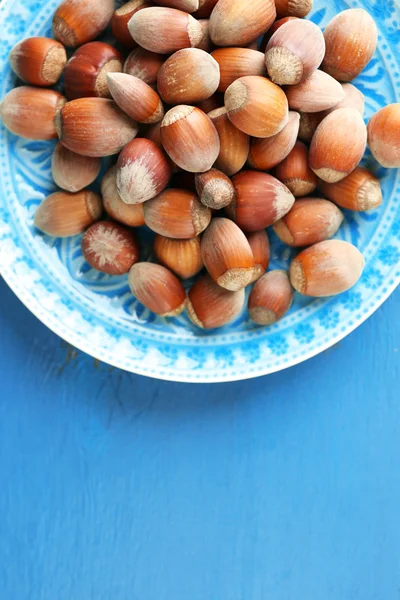 Hazelnuts on blue plate — Stock Photo, Image
