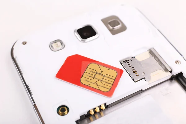 Мобильный телефон и сим-карта, изолированные на белом — стоковое фото