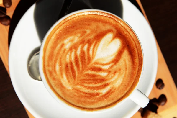 Tasse Kaffee mit süßer Zeichnung im Café — Stockfoto