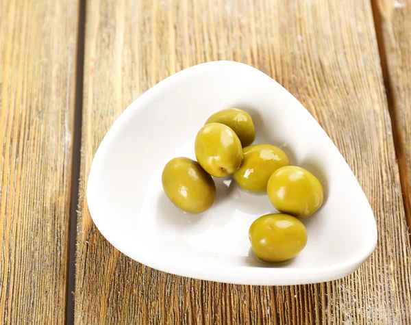 Olives vertes dans un bol sur la table close-up — Photo