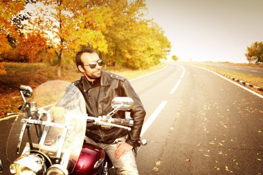 Motorcu adam bisiklet üzerinde oturur