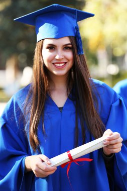 Yüksek lisans öğrencileri mezuniyet şapka ve elbise, açık havada giyiyor