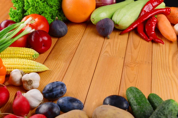Frutas e legumes orgânicos frescos sobre fundo de madeira — Fotografia de Stock