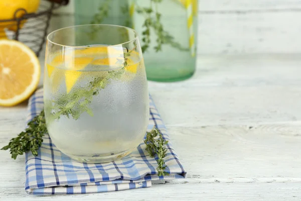 Sabrosa bebida fresca con limón y tomillo, sobre fondo de madera —  Fotos de Stock