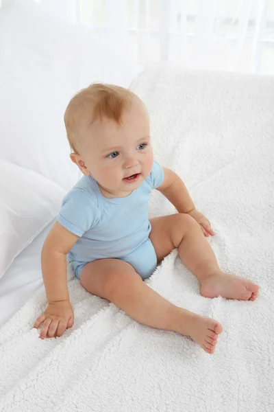 Schattige babyjongen op bed in kamer — Stockfoto