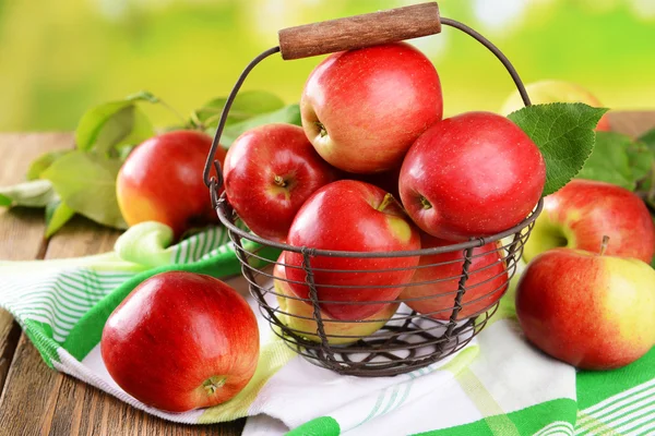 Słodkie jabłka w wiklinowym koszu — Zdjęcie stockowe