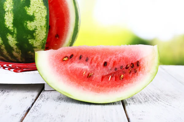 Watermelon on napkin on wooden table — Stock Photo, Image