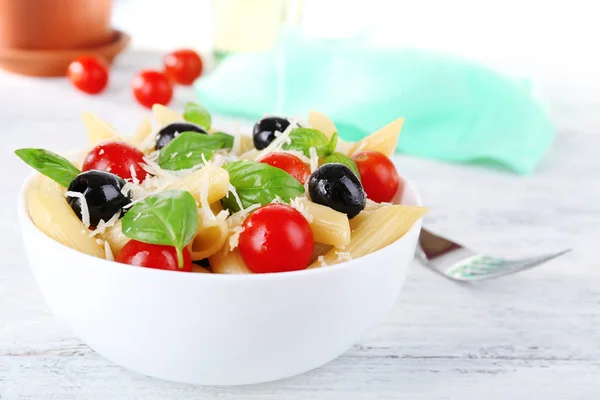 Pasta con tomates, aceitunas y hojas de albahaca — Foto de Stock