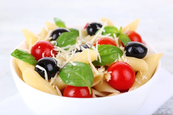 Pasta con tomates, aceitunas y hojas de albahaca — Foto de Stock