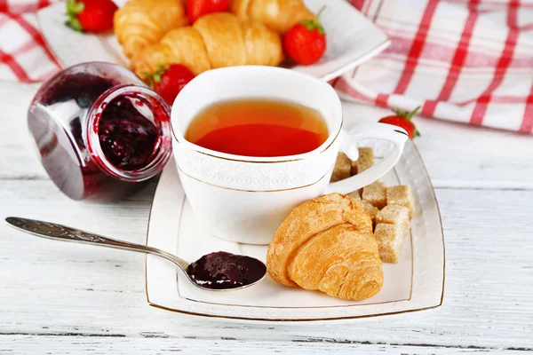 Ontbijt met thee, jam en croissants — Stockfoto