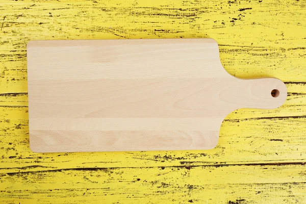 Cutting board on wooden background — Stock Photo, Image