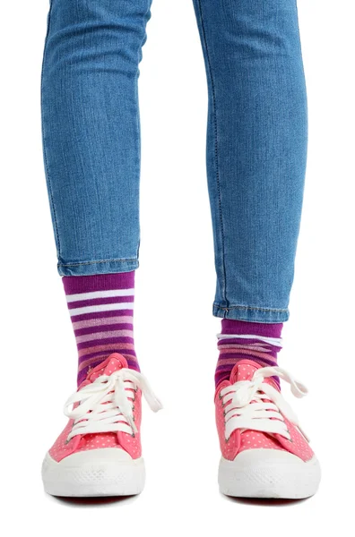 Patas femeninas en calcetines y zapatillas de deporte de colores — Foto de Stock