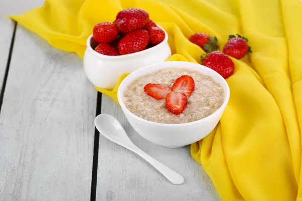 Harina de avena con fresas en la mesa — Foto de Stock