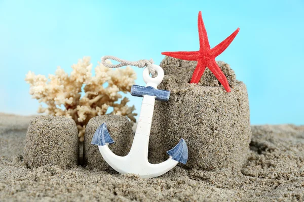 Sandcastle with starfish on beach — Stock Photo, Image