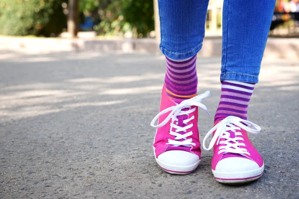 Patas femeninas en calcetines y zapatillas deportivas — Foto de Stock