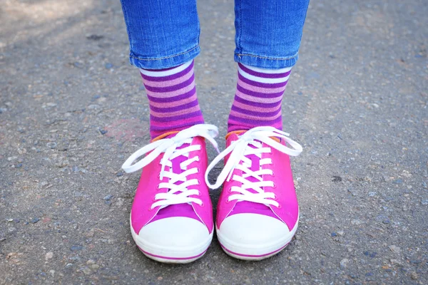 Patas femeninas en calcetines y zapatillas deportivas — Foto de Stock