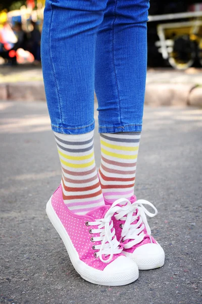 女性的双腿，穿着五颜六色的袜子和运动鞋 — 图库照片